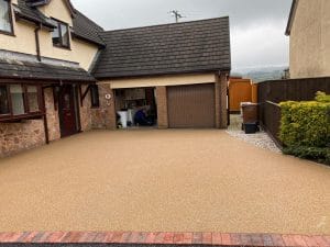 Choosing the right Paving Material for your driveway with a Resin Driveway to match the brick on a modern house